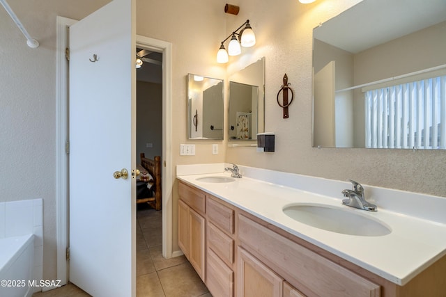 bathroom with tile patterned flooring, vanity, and a bath