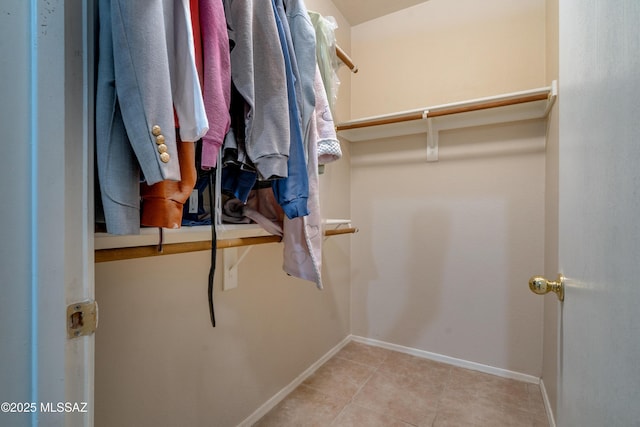 walk in closet with light tile patterned floors