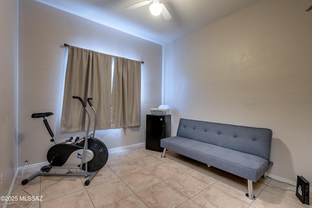 exercise room with light tile patterned floors and ceiling fan