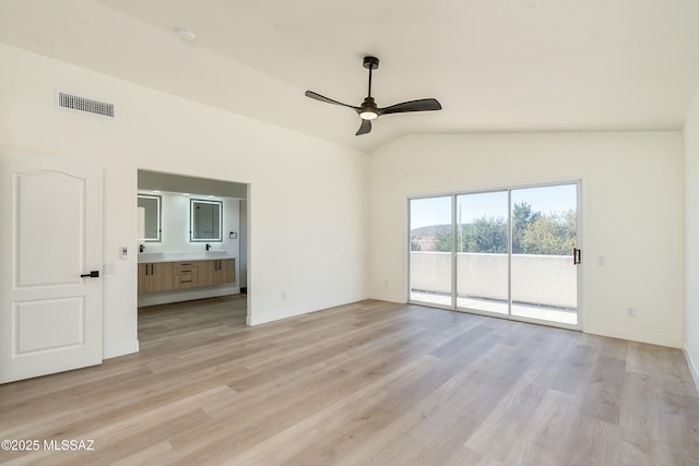 spare room featuring ceiling fan, lofted ceiling, and light wood-type flooring