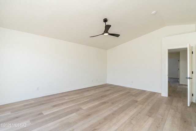 spare room featuring ceiling fan, lofted ceiling, and light wood-type flooring