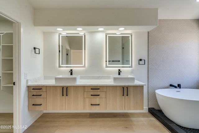 bathroom featuring vanity, wood-type flooring, and a washtub