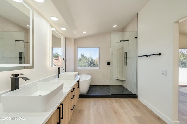 bathroom with vaulted ceiling, separate shower and tub, hardwood / wood-style floors, and vanity