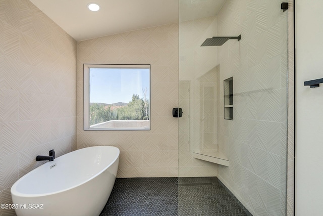 bathroom featuring tile patterned floors, independent shower and bath, and tile walls