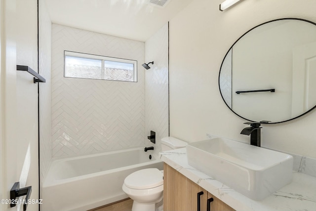 full bathroom with vanity, tiled shower / bath, and toilet