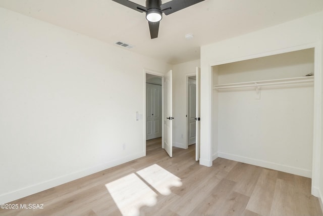 unfurnished bedroom featuring light hardwood / wood-style floors, a closet, and ceiling fan