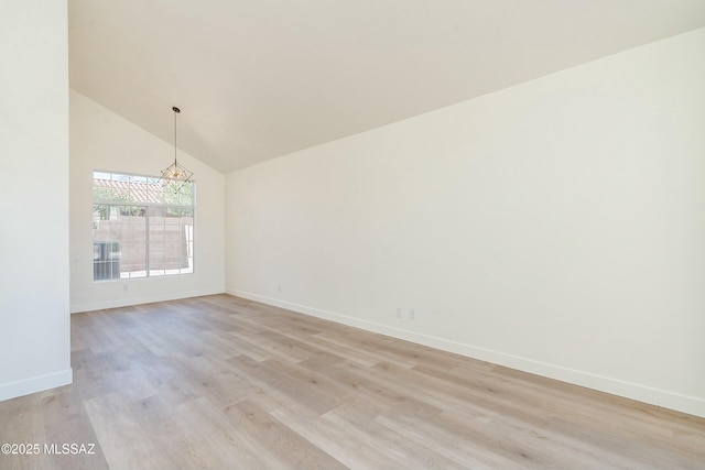 unfurnished room featuring a notable chandelier, high vaulted ceiling, and light wood-type flooring