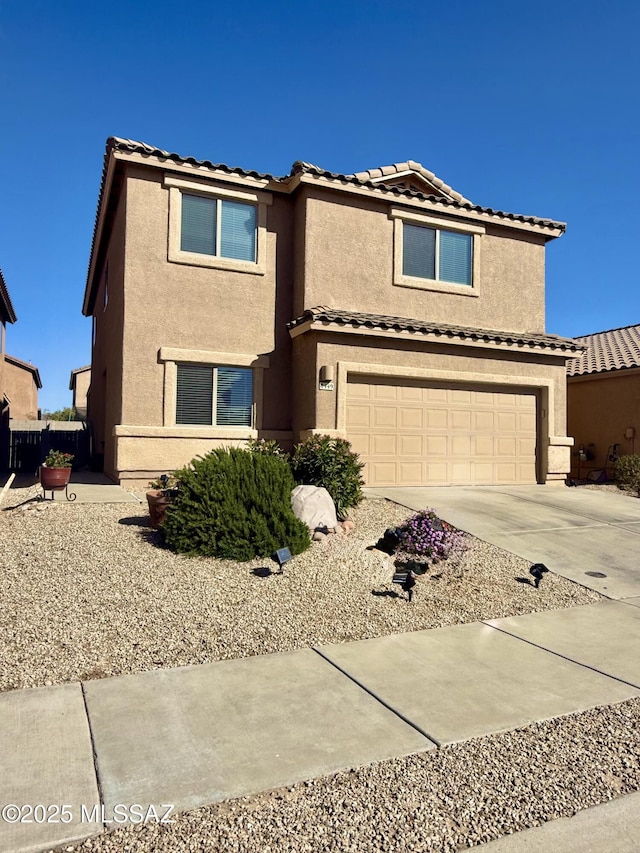 traditional home with a tiled roof, stucco siding, driveway, and a garage