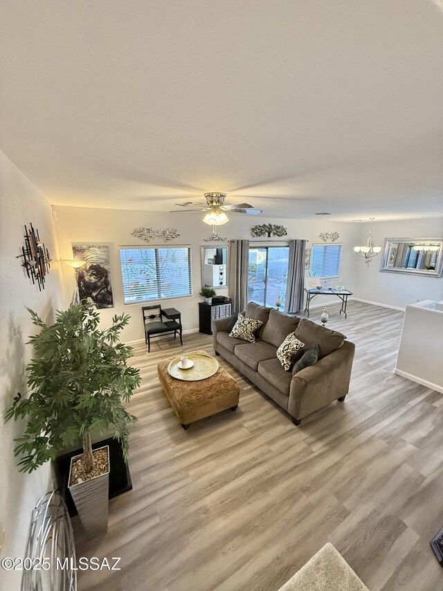 spare room featuring ceiling fan with notable chandelier and dark wood-type flooring