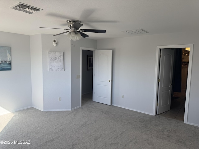 unfurnished bedroom featuring ceiling fan, light carpet, and a textured ceiling