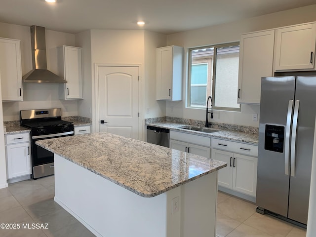 kitchen with a kitchen island, sink, white cabinets, stainless steel appliances, and wall chimney range hood