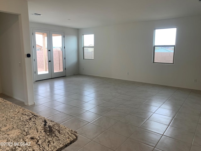 tiled empty room with french doors and plenty of natural light