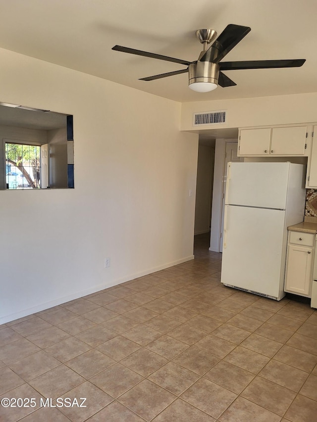 kitchen featuring white refrigerator, light tile patterned floors, white cabinets, and ceiling fan