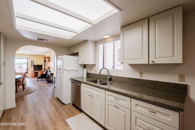 kitchen with white cabinetry, sink, white refrigerator, stainless steel dishwasher, and light hardwood / wood-style floors