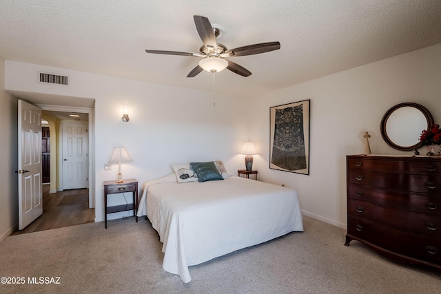 bedroom with ceiling fan, a textured ceiling, and carpet flooring