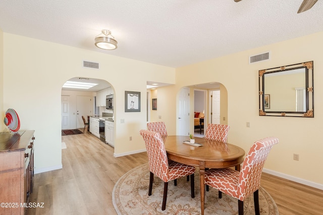 dining area featuring a textured ceiling and light wood-type flooring