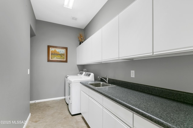 clothes washing area featuring cabinets, sink, light tile patterned floors, and washer and clothes dryer