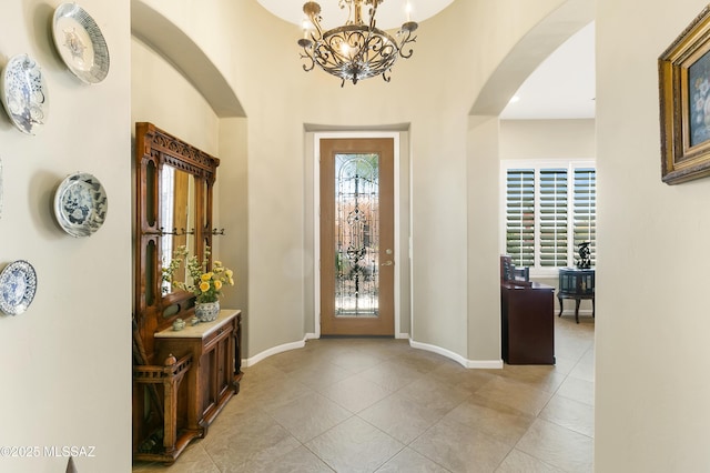 tiled foyer featuring a notable chandelier and a healthy amount of sunlight