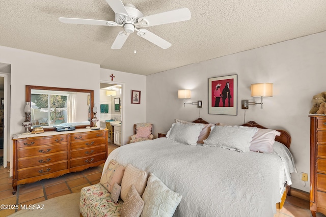 bedroom with ceiling fan, connected bathroom, and a textured ceiling