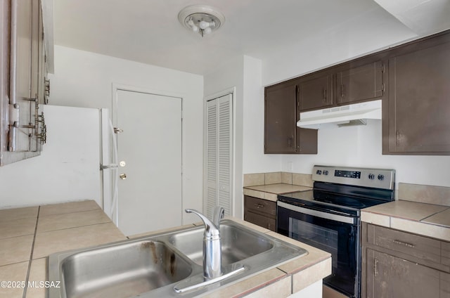 kitchen featuring dark brown cabinetry, sink, electric range, tile counters, and white fridge