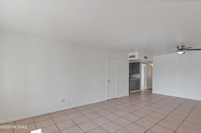 tiled empty room featuring ceiling fan