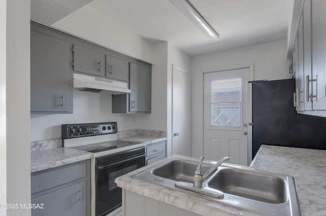 kitchen with sink, black electric range, gray cabinetry, and stainless steel refrigerator