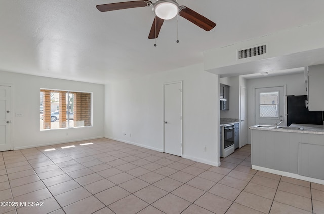 unfurnished living room with ceiling fan and light tile patterned floors