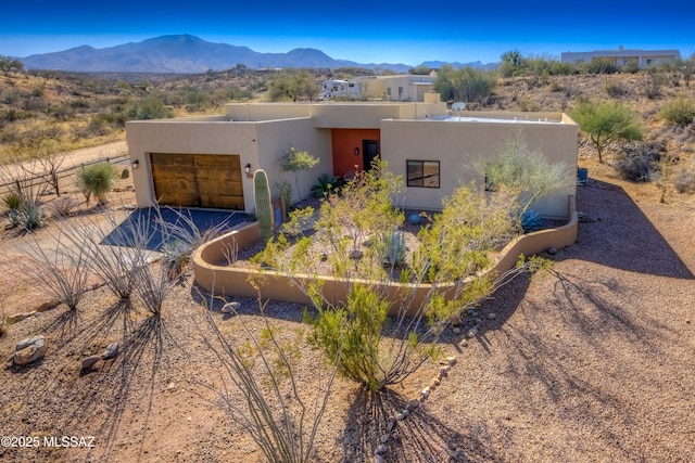 pueblo-style house with a mountain view and a garage