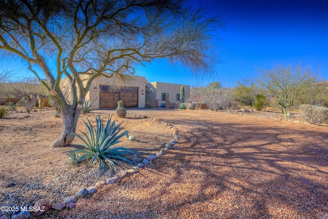 pueblo revival-style home with a garage