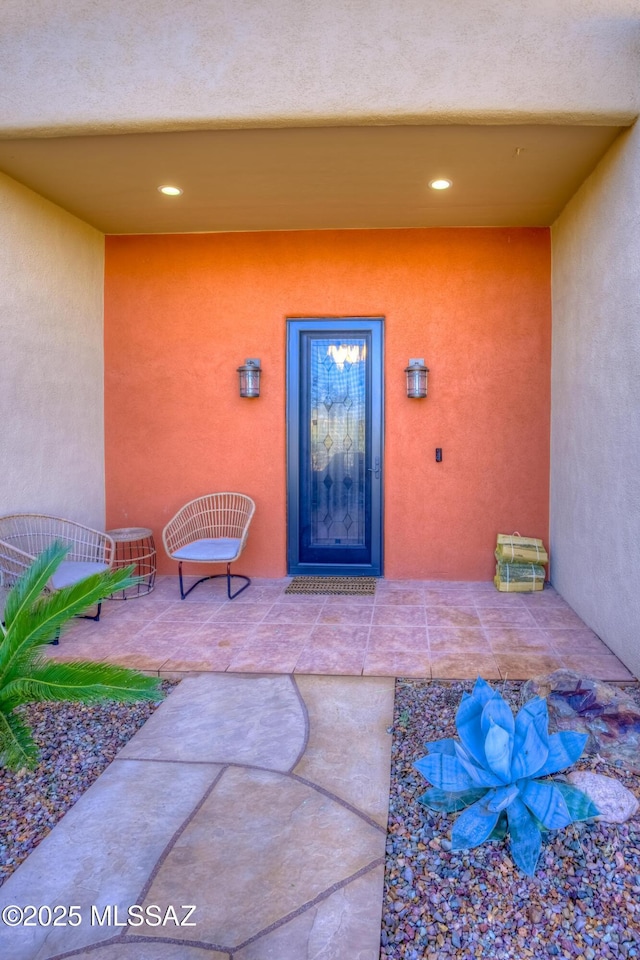 view of exterior entry with a patio