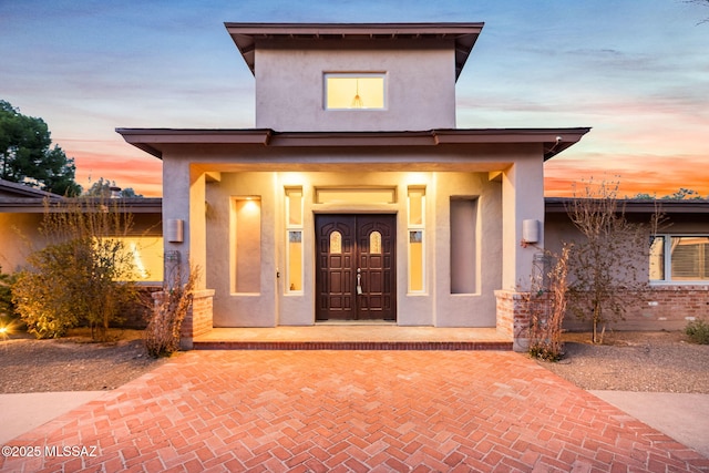 view of front facade featuring covered porch and stucco siding