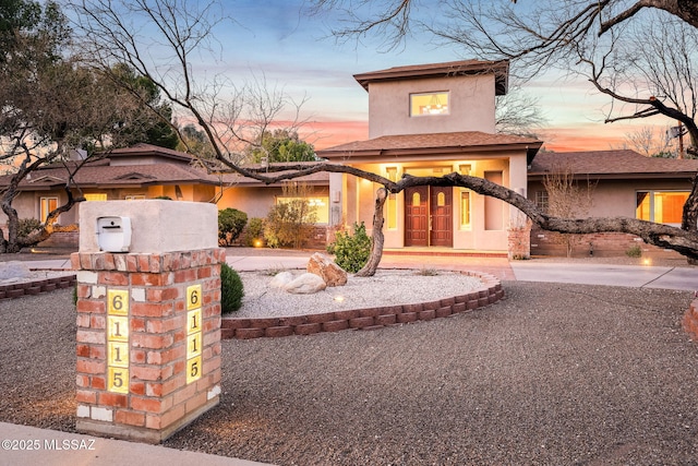 mediterranean / spanish house featuring stucco siding, decorative driveway, and french doors