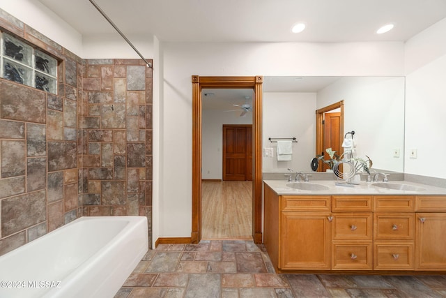 full bath featuring double vanity, stone finish floor, a sink, and baseboards