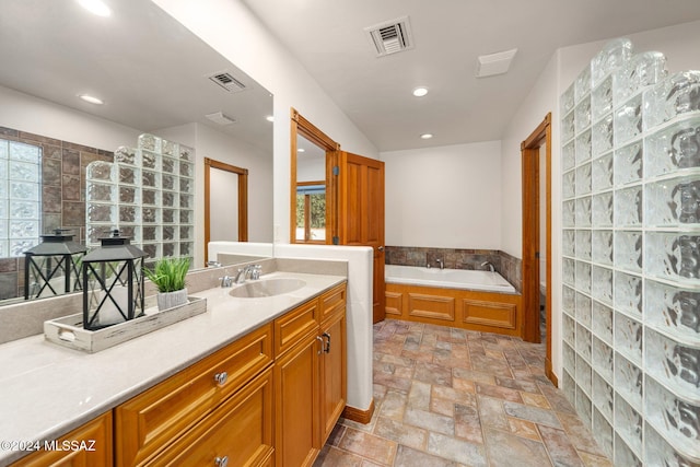 full bathroom with stone finish floor, visible vents, and a healthy amount of sunlight