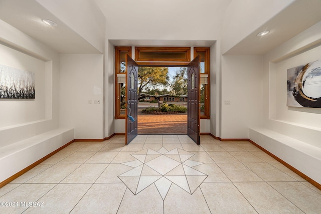 foyer entrance with recessed lighting, baseboards, and light tile patterned floors