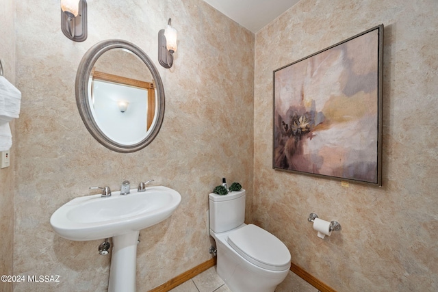 bathroom with toilet, tile patterned flooring, and baseboards