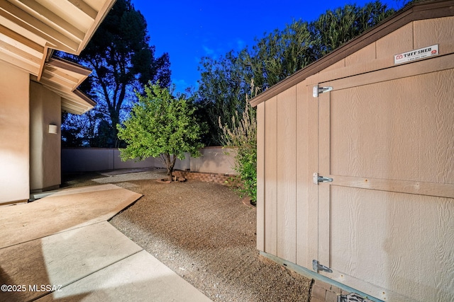 yard at night featuring a patio area and a fenced backyard