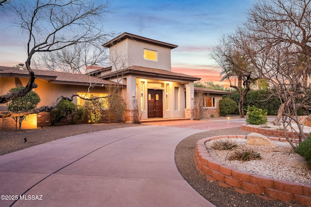 view of front of property with french doors, decorative driveway, and stucco siding