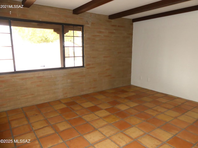 tiled empty room featuring beamed ceiling