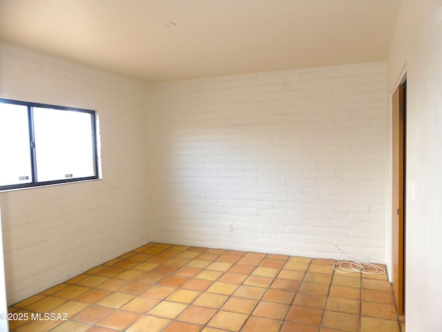 empty room featuring brick wall