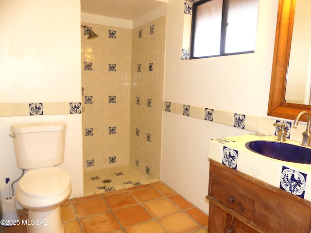 bathroom featuring vanity, tile patterned flooring, tile walls, and toilet