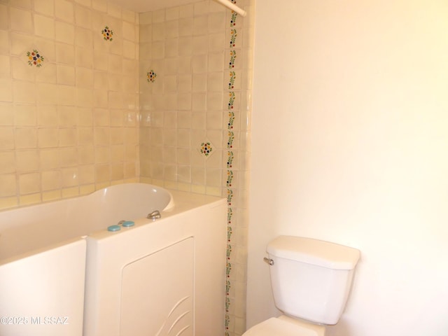 bathroom with tiled shower / bath combo and toilet