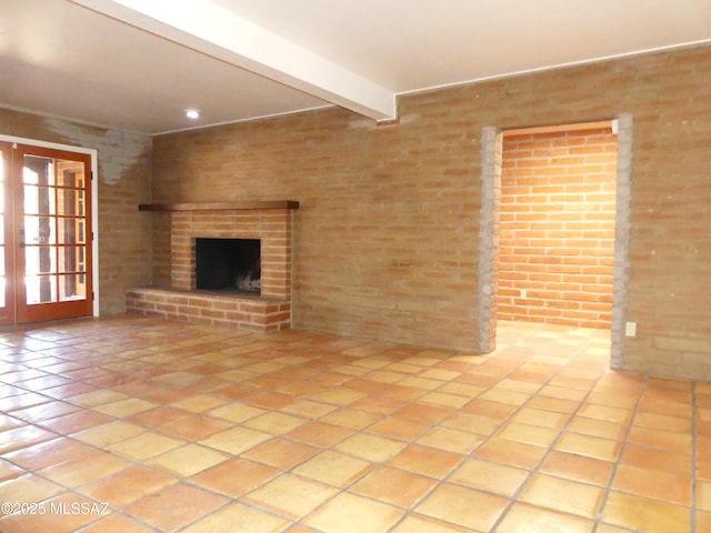 unfurnished living room with beam ceiling and a brick fireplace