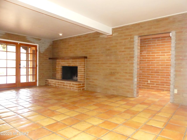 unfurnished living room with beamed ceiling, a brick fireplace, french doors, and light tile patterned floors