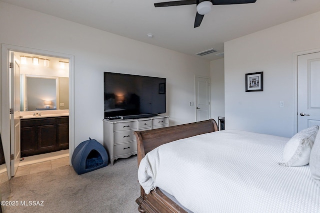 carpeted bedroom featuring sink, ensuite bath, and ceiling fan