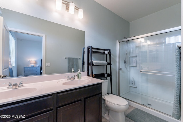 bathroom featuring tile patterned flooring, vanity, toilet, and a shower with shower door