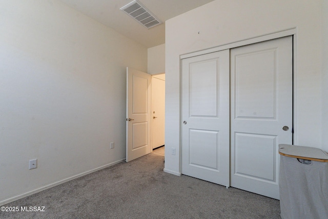 unfurnished bedroom with light colored carpet and a closet