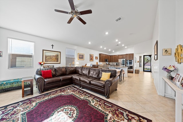 living room featuring lofted ceiling, light tile patterned floors, and ceiling fan