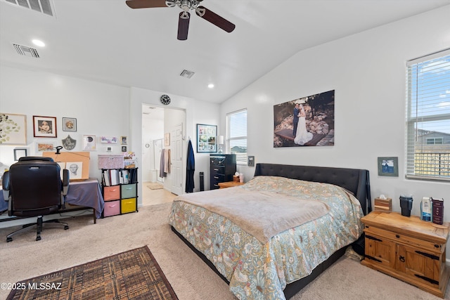 bedroom with lofted ceiling, connected bathroom, light carpet, and ceiling fan