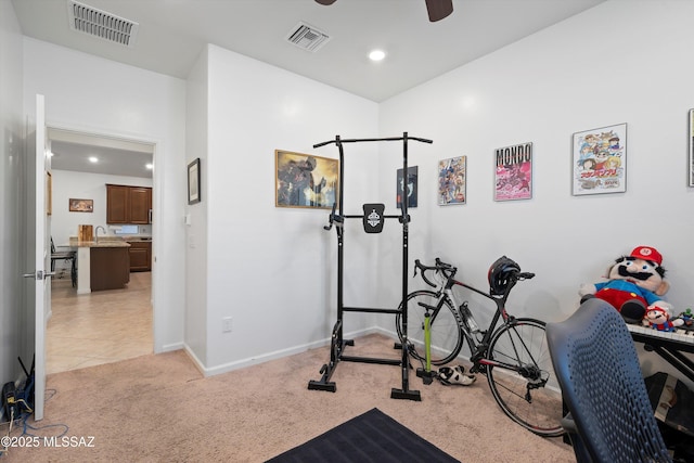 workout area with sink, light carpet, and ceiling fan